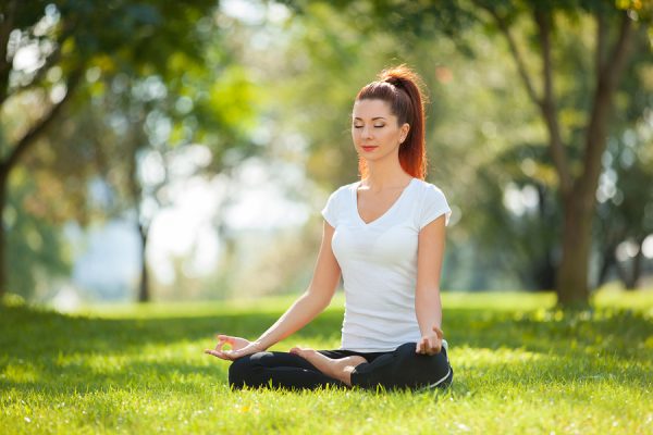 woman meditating in the park